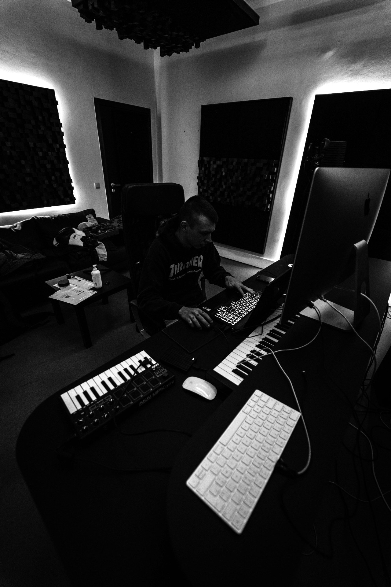 An artist at work in a dark studio, lit by a single keyboard